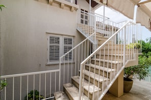 Staircase leads to an upper floor in this well-maintained building with a potted plant on the ground floor.