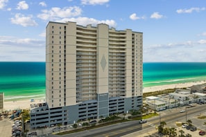 Un grand hôtel à plusieurs étages, doté d’un parking et offrant une vue sur la plage.