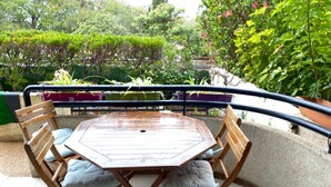 A round wooden table with cushioned chairs, surrounded by a curved balcony with a metal railing. - Casa Familia (La Orotava)
