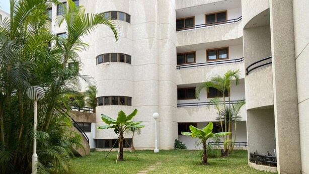 A courtyard with a building featuring multiple balconies and a central open space with grass and small trees. - Casa Familia (La Orotava)