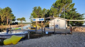 Een strandski-club met een houten pier, een klein gebouw en een heldere lucht.