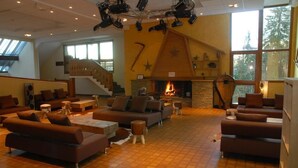 A spacious living area with multiple sofas, a fireplace, and a staircase leading to an upper level.