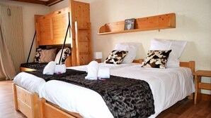 A double bed with a black and white patterned blanket, wooden headboard, and two bedside tables.