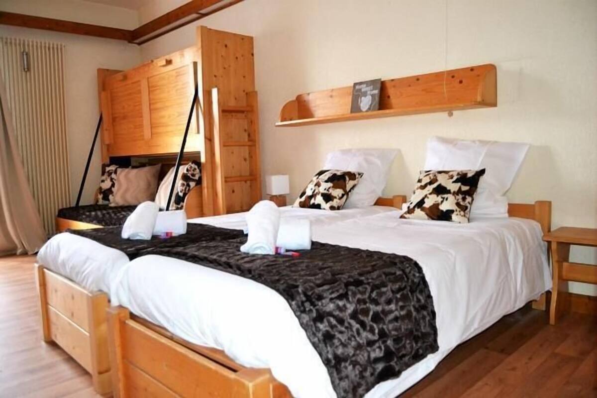 Ein Doppelbett mit einer schwarz-weißen Bettdecke, einem Holz-Kopfseitenverkleidung und zwei Nachttischen.