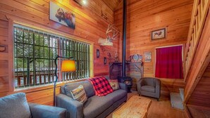 A cabin interior with a sofa, armchair, and a fireplace. - 6 Cabins with Kitchens+Gameroom&Playground (Payson)
