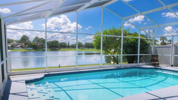 Piscina com vista para um lago e vegetação ao redor.