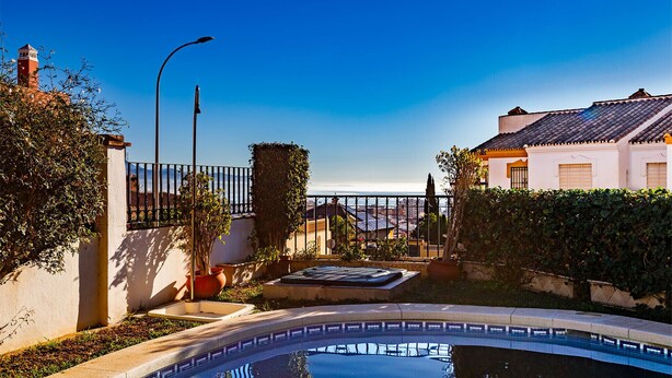 A swimming pool with a tiled deck, surrounded by a fence, and a lamp post. - A&n Moriles 2      . (Torre del Mar)