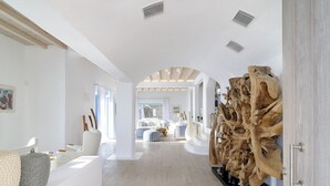 Un intérieur spacieux et moderne, avec un plancher en bois, des meubles blancs et une grande sculpture en bois.