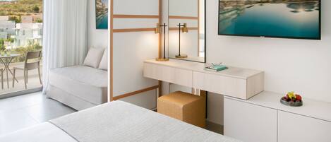 A modern hotel room with a bed, a desk, a chair, a small table, a mirror, and a TV.