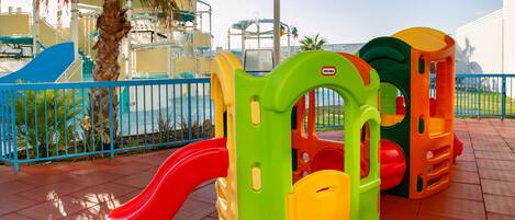 A children's play area with a slide and climbing structures.