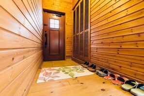 Guests can walk down this hallway lined with doors and shoe storage.
