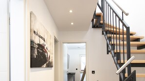 A modern interior with a staircase, a hallway, and a dining area. - House Comfort, with outdoor whirlpool and sauna for exclusive use, 300m to the lake (Göhren-Lebbin)