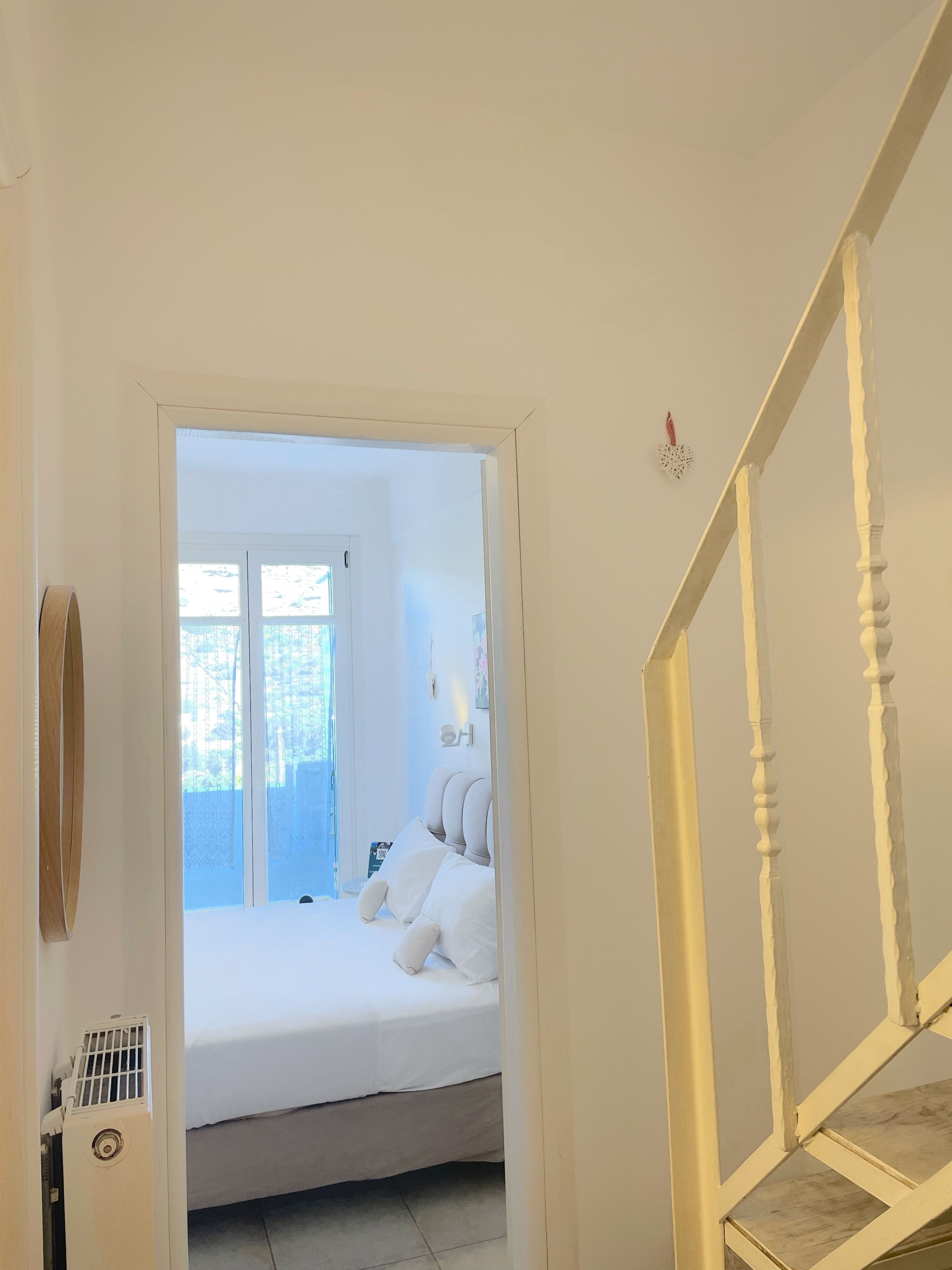 Un dormitorio con cama, ventana y puerta que da a otra habitación.