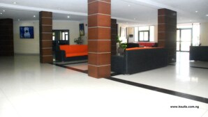 A spacious lobby with a reception desk, a sofa, and a large window. - K Suite Hotels (Kano)