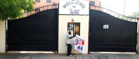A gated entrance with a sign reading "WELCOME TO K. SUITE HOTEL".