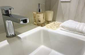 Chuveiro, secador de cabelo, toalhas de banho, papel higiênico