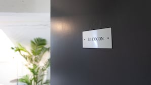 Un mur sur lequel est affiché un panneau indiquant : « LE COCON ».
