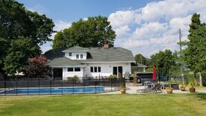 A two-story house with a swimming pool, surrounded by a fenced yard and potted plants. - Updated Heritage House close to Naramata Bench (Penticton)