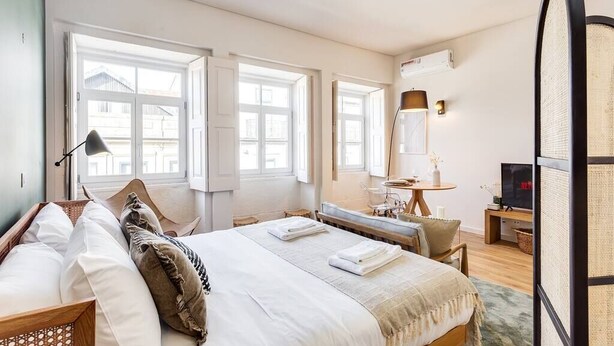 A well-lit hotel room with a large bed, bedside tables, a desk, and a television. - Boavista Green Studio by DA'HOME (Porto)