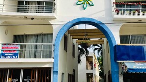 Hotel Rio Balsa with a prominent entrance, a flower logo, and a sign for rental departments. - Hotel Rio Balsas (Manzanillo)