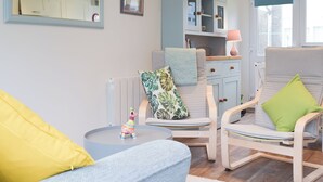 A living room with a sofa, two chairs, a small table, a cabinet, and a mirror. - Sanderling - UK32837 (Freshwater East, near Pembroke)