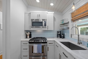 Una cocina moderna con electrodomésticos de acero inoxidable, horno integrado, estufa y lavaplatos.