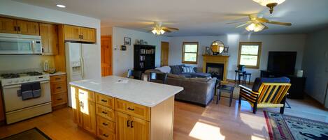 A spacious kitchen with wooden cabinets, a central island, and a dining area with a chair.