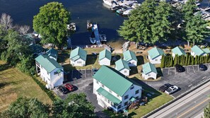 A residential area with multiple houses, a dock with boats, and a parking lot. - On the water, 35' DOCK SPACE! CENTER OF NAPLES! Access to Sebago and Long Lakes (Naples)