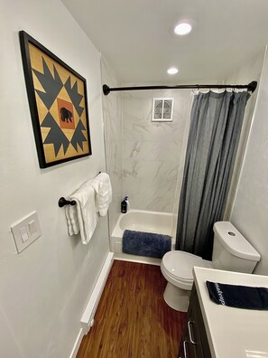 A bathroom with a bathtub, toilet, and a shower curtain. - 26/27 El Nino Winter Basecamp! Fully stocked, fresh design, private condo! (Silverthorne)