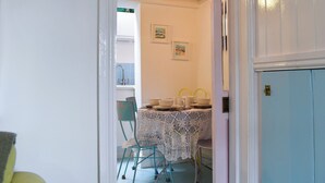 A dining area with a table set for four, chairs, and a window with a view. - 2 bedroom accommodation in St Ives (St Ives)