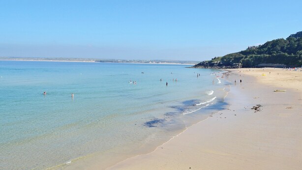 A beach with clear water, a sandy shore, and a hilly landscape in the background. - 2 bedroom accommodation in St Ives (St Ives)
