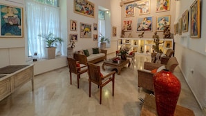 Un salón amplio con techo alto, vigas de madera y una variedad de obras de arte en las paredes.