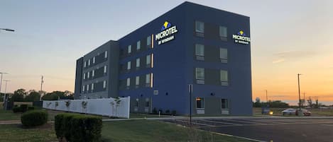 A modern Microtel hotel by Wyndham with a flat facade, multiple windows, and a parking lot.