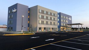 A Microtel hotel with a modern design, featuring multiple floors and a covered entrance area. - Microtel Inn & Suites by Wyndham Milford (Milford)