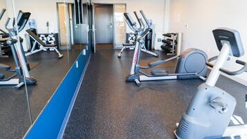 A gym with various exercise equipment, including treadmills and elliptical machines.