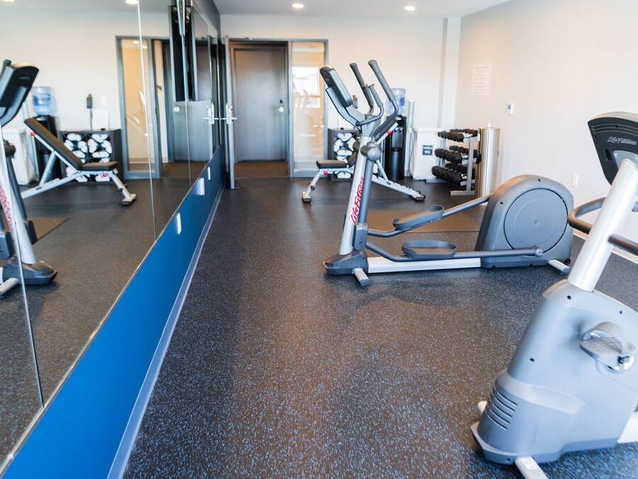 A gym with various exercise equipment, including treadmills and elliptical machines.