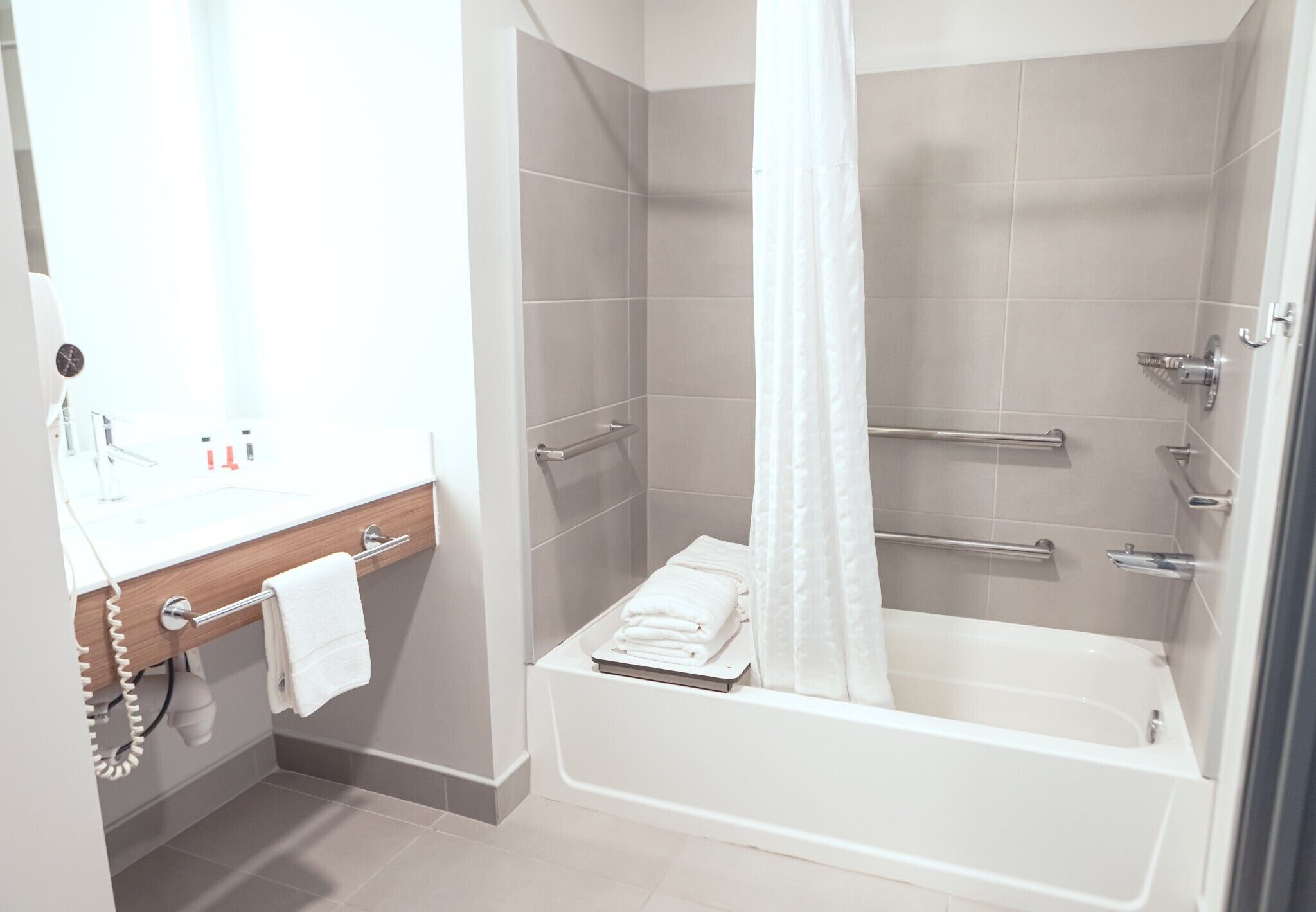 Une salle de bain moderne équipée d’une baignoire, d’une douche et d’un meuble-lavabo.