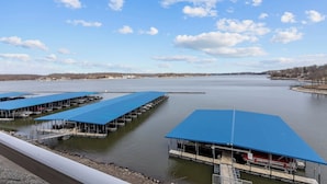 A waterfront marina with multiple docked boats and covered structures.