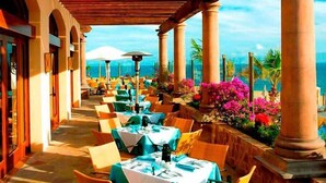 A covered outdoor dining area with tables and chairs, columns, and a view of the sea. - Gorgeous 3BR Villa Perfect View at Cabo San Lucas (Cabo San Lucas)