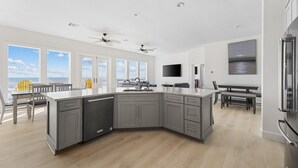 Una cocina moderna con una isla grande, electrodomésticos integrados y vistas al océano.