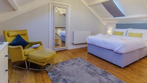 A bedroom with a bed, a chair, a mirror, and a skylight. - Rural romantic getaway for two. (Neath)