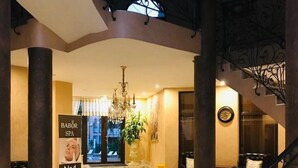 A lobby with marble flooring, a chandelier, and a staircase with ornate railings. - New Modern Studio - Artur, Sveti Vlas - Apartello (Sveti Vlas)