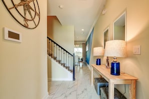 Stunning hallway with a marble floor, decorative piece, and console table with lamps.