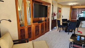 A living room with a sofa, TV, and dining area. - SuitestayLV~1BR Corner PH Suite/Balcony 31st Floor (Las Vegas)