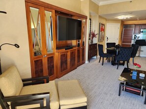 A living room with a sofa, TV, and dining area. - SuitestayLV~1BR Corner PH Suite/Balcony 31st Floor (Las Vegas)