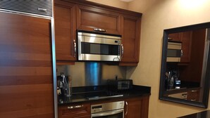 A modern kitchen with wooden cabinets, stainless steel appliances, and a black countertop. - SuitestayLV~1BR Corner PH Suite/Balcony 31st Floor (Las Vegas)