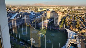 An aerial view of a cityscape with a large stadium, surrounding buildings, and a mountain in the background. - SuitestayLV~1BR Corner PH Suite/Balcony 31st Floor (Las Vegas)