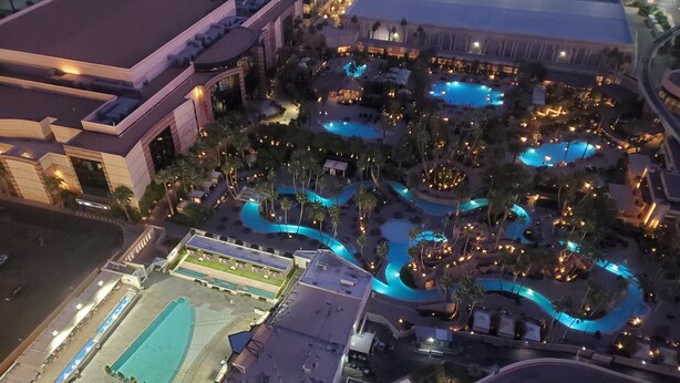 An aerial view of a hotel with multiple swimming pools, a tennis court, and a parking area. - SuitestayLV~1BR Corner PH Suite/Balcony 31st Floor (Las Vegas)