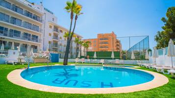 Een buitenzwembad, parasols bij het zwembad en ligstoelen