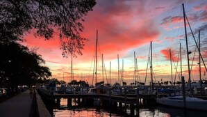 Un puerto deportivo con barcos amarrados al muelle al atardecer.